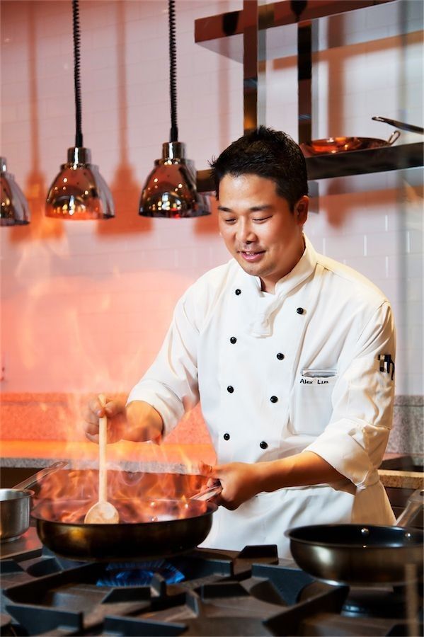 Head chef Alex Lim finishing a dish under the pass lights